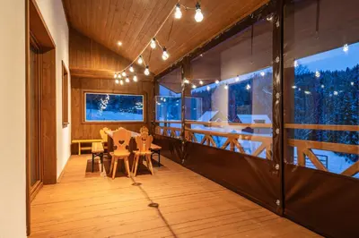 a room with a table and chairs on a balcony at Burnosówka in Nowy Targ