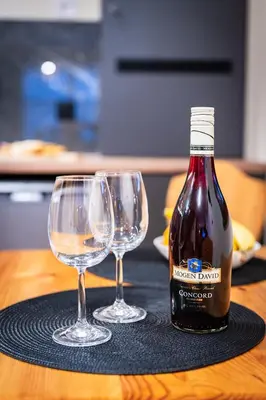 a bottle of wine and two wine glasses on a table at Burnosówka in Nowy Targ