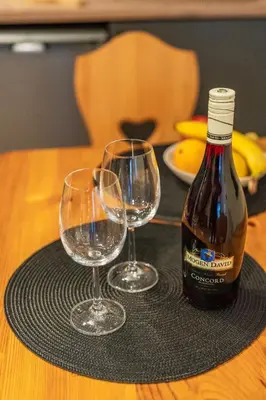 a bottle of wine and two wine glasses on a table at Burnosówka in Nowy Targ