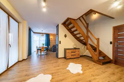 a living room with a staircase and a table at Burnosówka in Nowy Targ