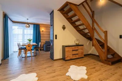 a living room with a table and a staircase at Burnosówka in Nowy Targ