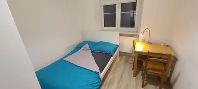 a small room with a bed and a desk at Centrally located cozy apartment in Kraków