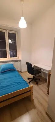 a bedroom with a bed and a desk and a chair at Centrally located cozy apartment in Kraków