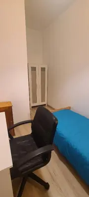 a black chair in a room with a bed at Centrally located cozy apartment in Kraków