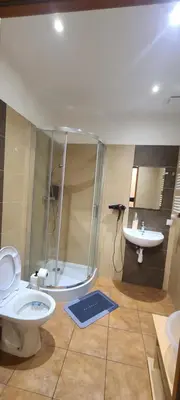 a bathroom with a shower and a toilet and a sink at Centrally located cozy apartment in Kraków