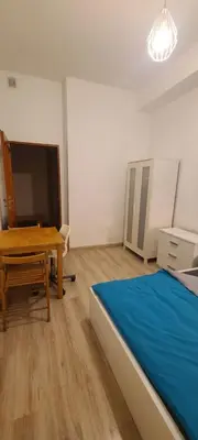 a bedroom with a bed and a table and a tv at Centrally located cozy apartment in Kraków