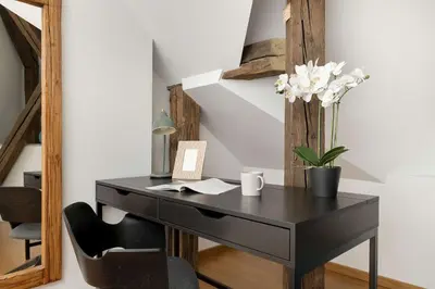 a black desk with a chair and a vase of flowers at Modern Apartment with Air Conditioning and Terrace near Old Town in Cracow by Noclegi Renters in Kraków