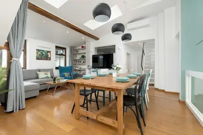 a dining room and living room with a wooden table and chairs at Modern Apartment with Air Conditioning and Terrace near Old Town in Cracow by Noclegi Renters in Kraków
