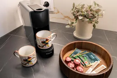 a counter with two cups and a coffee maker at Malila Premium Apartments Estery Boutique in Kraków