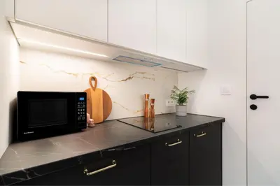 a kitchen with a black microwave on a counter at Malila Premium Apartments Estery Boutique in Kraków