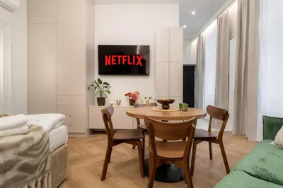 a kitchen and living room with a table and chairs at Malila Premium Apartments Estery Boutique in Kraków
