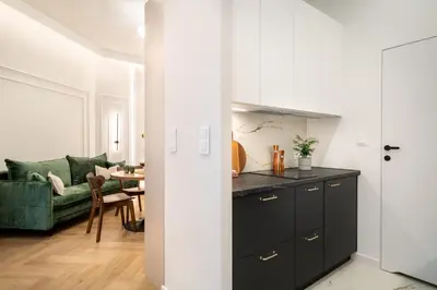 a kitchen and living room with a green couch at Malila Premium Apartments Estery Boutique in Kraków