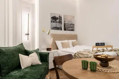 a living room with a green couch and a table at Malila Premium Apartments Estery Boutique in Kraków