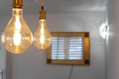 two lights hanging from a ceiling with a mirror at Bronowice Spacious Apartment by BookingHost in Kraków