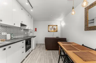 a kitchen with white cabinets and a wooden table at Bronowice Spacious Apartment by BookingHost in Kraków