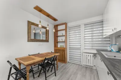 a kitchen with a wooden table and black chairs at Bronowice Spacious Apartment by BookingHost in Kraków