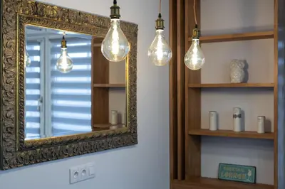 a mirror and some lights in a room at Bronowice Spacious Apartment by BookingHost in Kraków