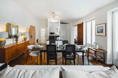 a dining room and living room with a table and chairs at Antique Apartments - Tomasza 6A in Kraków