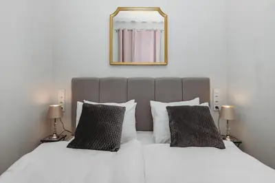 a bed with two pillows and a mirror on the wall at Antique Apartments - Tomasza 6A in Kraków