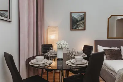 a living room with a dining room table with chairs at Antique Apartments - Tomasza 6A in Kraków