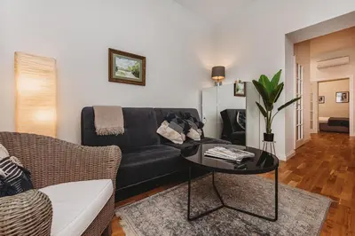 a living room with a black couch and a table at Antique Apartments - Tomasza 6A in Kraków
