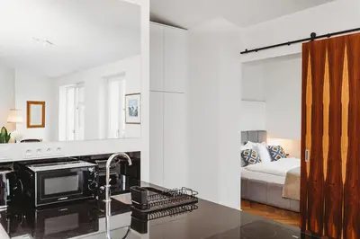 a kitchen with a stove and a bed in a room at Antique Apartments - Tomasza 6A in Kraków