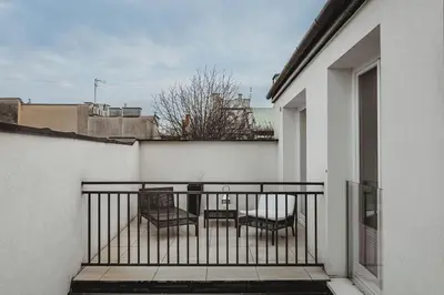 a balcony with chairs and tables on a building at Antique Apartments - Tomasza 6A in Kraków