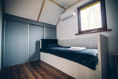 a small room with a bed and a window at Zacisze Krzeszów in Krzeszów