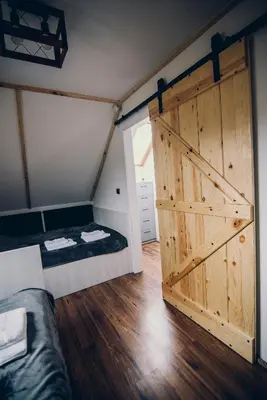 a room with a barn door and a bed at Zacisze Krzeszów in Krzeszów