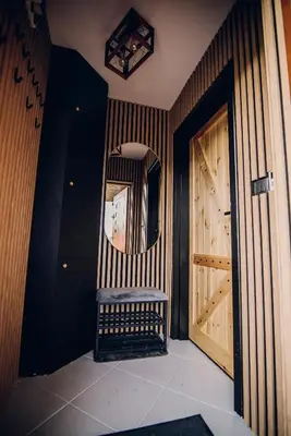 a hallway with a chair and a mirror and a door at Zacisze Krzeszów in Krzeszów
