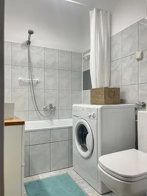 a bathroom with a washing machine and a toilet at Studio Krowodrza Centrum in Kraków