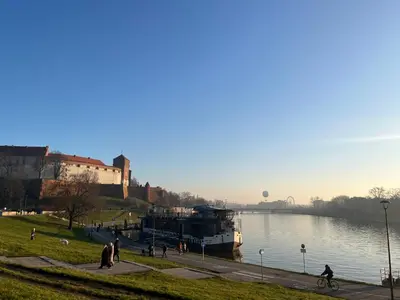 a boat is docked next to a river at Studio Krowodrza Centrum in Kraków