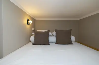 a bedroom with a large white bed with pillows at Modern apartment -Berka Joselewicza 5 street in Kraków