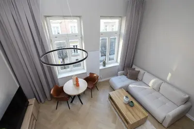 a living room with a white couch and a table at Modern apartment -Berka Joselewicza 5 street in Kraków