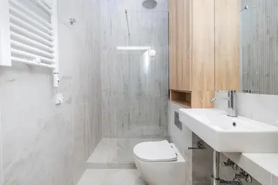 a white bathroom with a toilet and a sink at Modern apartment -Berka Joselewicza 5 street in Kraków