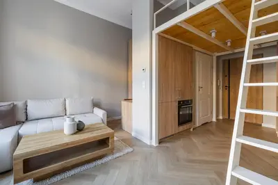 a living room with a white couch and a ladder at Modern apartment -Berka Joselewicza 5 street in Kraków