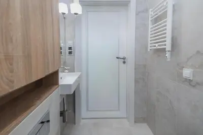 a white bathroom with a sink and a shower at Modern apartment -Berka Joselewicza 5 street in Kraków