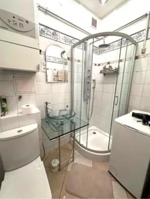 a bathroom with a glass shower and a toilet at Jubilat Apartament in Kraków