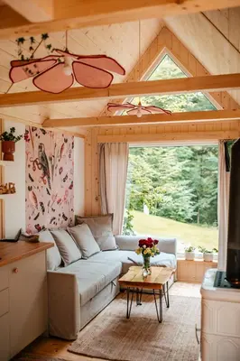 an outdoor living area with a pergola on a wooden deck at Tiny house nad potokiem in Ohłypów