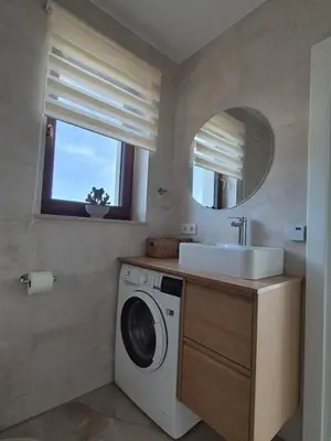 a bathroom with a washing machine and a sink at Domek Pod Babim Szczytem in Zubrzyca Górna