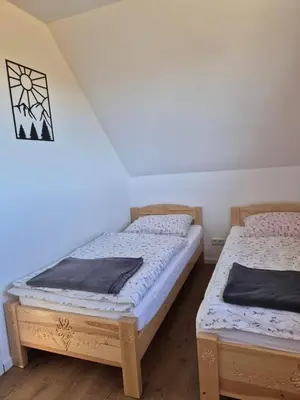 two twin beds in a room with a wall at Domek Pod Babim Szczytem in Zubrzyca Górna