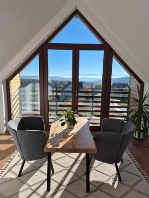a room with a table and two chairs and a large window at Domek Pod Babim Szczytem in Zubrzyca Górna