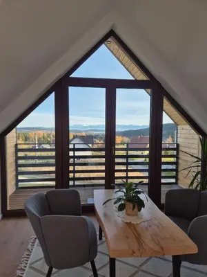 a room with a table and chairs and a large window at Domek Pod Babim Szczytem in Zubrzyca Górna