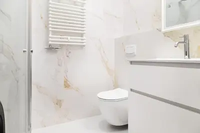 a white bathroom with a toilet and a sink at Househost Apartment Zacisze 16 in Kraków