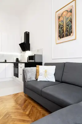 a living room with a couch and a kitchen at Househost Apartment Zacisze 16 in Kraków