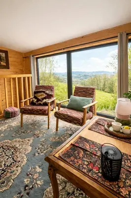 an aerial view of a house on a hill with mountains at Nastawka Cottage Creativity and Regeneration in Raciechowice