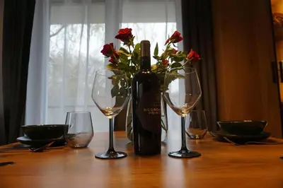 a table with a bottle of wine and two glasses at VIP Apartments Victoria in Wieliczka