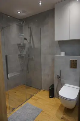 a bathroom with a toilet and a glass shower at VIP Apartments Victoria in Wieliczka