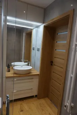 a bathroom with a sink and a mirror at VIP Apartments Victoria in Wieliczka