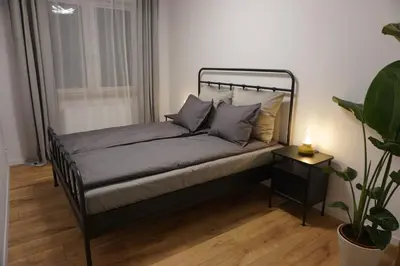 a bed in a small room with a plant at VIP Apartments Victoria in Wieliczka